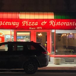 a car parked in front of a pizza restaurant a car parked in front of a pizza restaurant