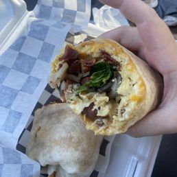 Sunrise breakfast burrito with bacon, cheddar, tomato, mushrooms, and spinach Sunrise breakfast burrito with bacon, cheddar, tomato, mushrooms, and spinach