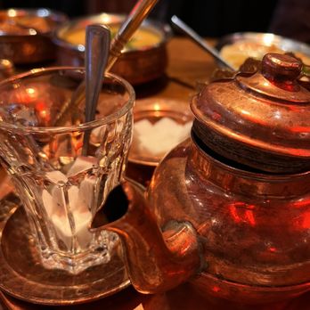 Roman Zaman - a copper teapot with a spoon in it - Middle Eastern Near Me - Mississauga, Ontario
