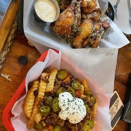 Garlic Parmesan wings and fries with sour cream, chili, and jalapeños.