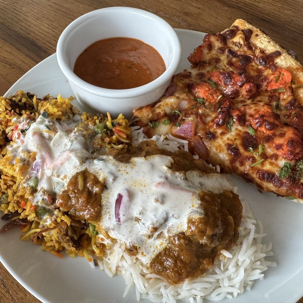 Butter chicken pizza, veg biryani, and goat curry over plain basmati Butter chicken pizza, veg biryani, and goat curry over plain basmati