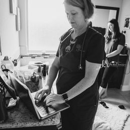 Margie (midwife) taking down client notes during birth Margie (midwife) taking down client notes during birth