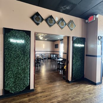Karachi Chatkhara - Party room - The image shows an indoor restaurant entrance with signs for Karachi and Lahore, decorated with framed Islamic art above the doorway, and a view of the dining area inside. - Pakistani Near Me - Mount Prospect, Illinois