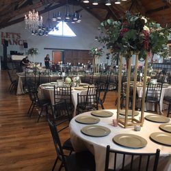 Moody Hues Floral - Our venue with arrangements on gold steel stands, lots of greenery and floral arrangements on tables.
