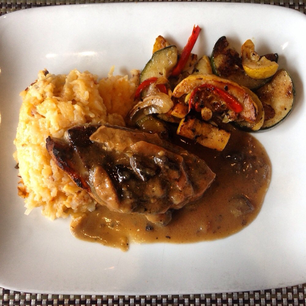 Rivertown Bistro - This is a split portion of the chargrilled pork chop with wild mushroom marsala gravy, hash brown casserole & grilled zucchini. - New American Near Me - Conway, South Carolina Rivertown Bistro - This is a split portion of the chargrilled pork chop with wild mushroom marsala gravy, hash brown casserole & grilled zucchini. - New American Near Me - Conway, South Carolina