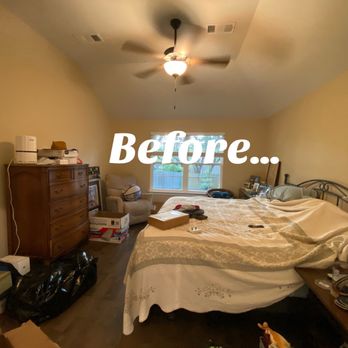 Creating Sacred Spaces - A bedroom with a bed, dresser, armchair, and window, cluttered with boxes and items, before cleaning or renovation. - Interior Design Near Me - Austin, Texas