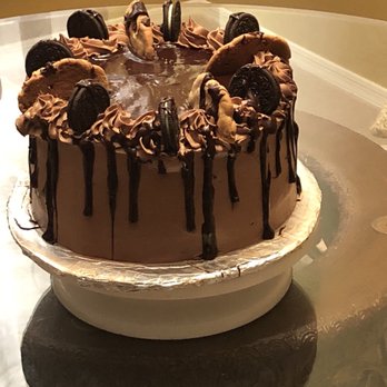Chrissy's Cupcakes & Desserts - a chocolate frosted cake with cookies on top - Cupcakes Near Me