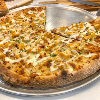 Collins Pizza - a pizza on a pan with a slice taken out of it - Pizza Near Me - Miami Beach, Florida