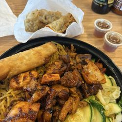 Large spicy chicken teriyaki with yakisoba, vegetables, chicken egg roll and pot stickers.