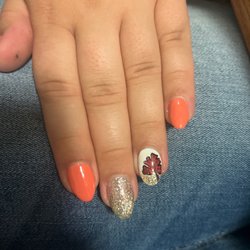 Fall themed nails, orange changes color to brown, and a leaf for an accent nail.