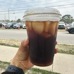 a hand holding a cup of iced coffee a hand holding a cup of iced coffee