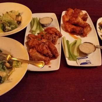 Madrones - Left to right: house salad (split into 2 bowls), tiger wings, buffalo wings, and fried calamari on a bed of greens - Steakhouses Near Me - Frederick, Maryland