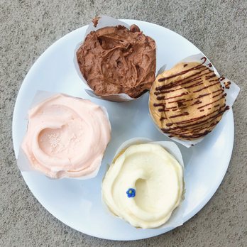 Baked & Wired - Four cupcakes: Chocolate, Elvis Impersonator (banana and peanut butter), Smurfette (lemon and blueberry), Strawberry - Bakeries Near Me - Washington, DC, District of Columbia