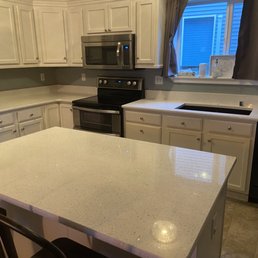 a kitchen countertop with a black refrigerator