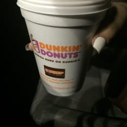  a hand holding a cup of coffee