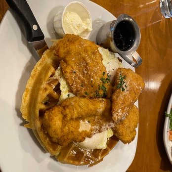 Canela Cafe - Chicken and waffles - with eggs added (peeking out under the chicken)! - Breakfast & Brunch Near Me - Milwaukee, Wisconsin
