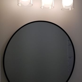 Taylor Made Improvements - a bathroom with a round mirror - General Contractors Near Me - Bryan, Ohio Taylor Made Improvements - a bathroom with a round mirror - General Contractors Near Me - Bryan, Ohio