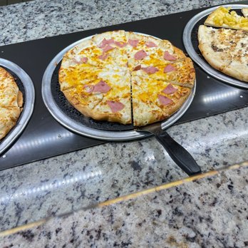 Cicis Pizza - three pizzas sitting on pans on a counter - Pizza Near Me - Clarksville, Tennessee