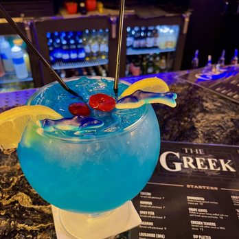 The Greek - a blue cocktail with a cherry garnish - Greek Near Me - Detroit, Michigan The Greek - a blue cocktail with a cherry garnish - Greek Near Me - Detroit, Michigan