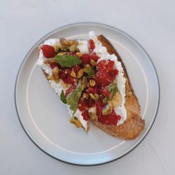 Smalls - Ricotta tartine: fresh raspberries, pistachio, lemon, mint, & honey on sourdough