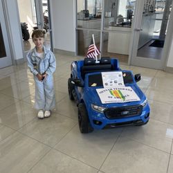 My daughter in their showroom next to a mini kids car that they are raffling off for Vietnam Veterans group!