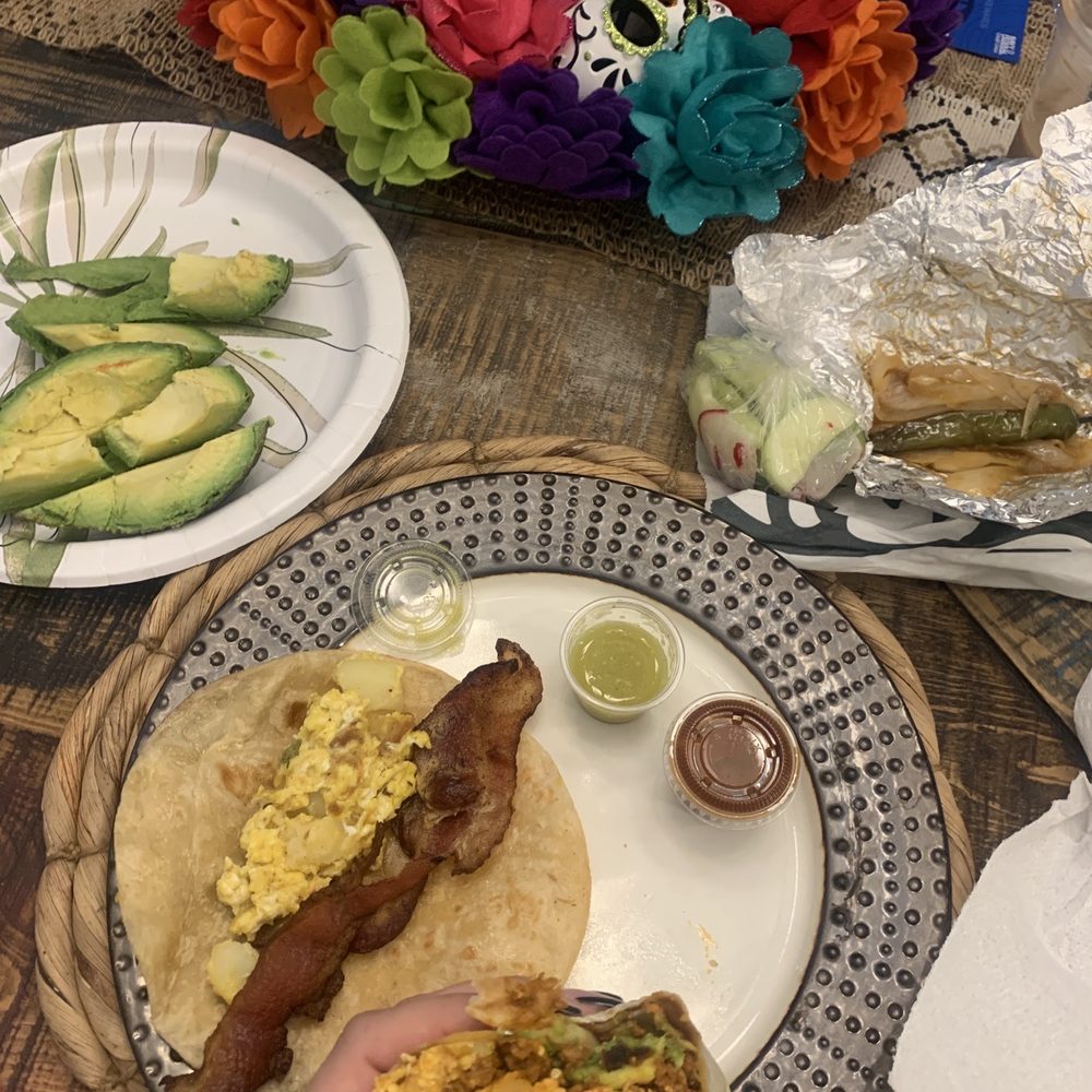 Chorizo egg and potato burrito with avocado and a bacon egg and potato taco, grilled onions and taco on the side