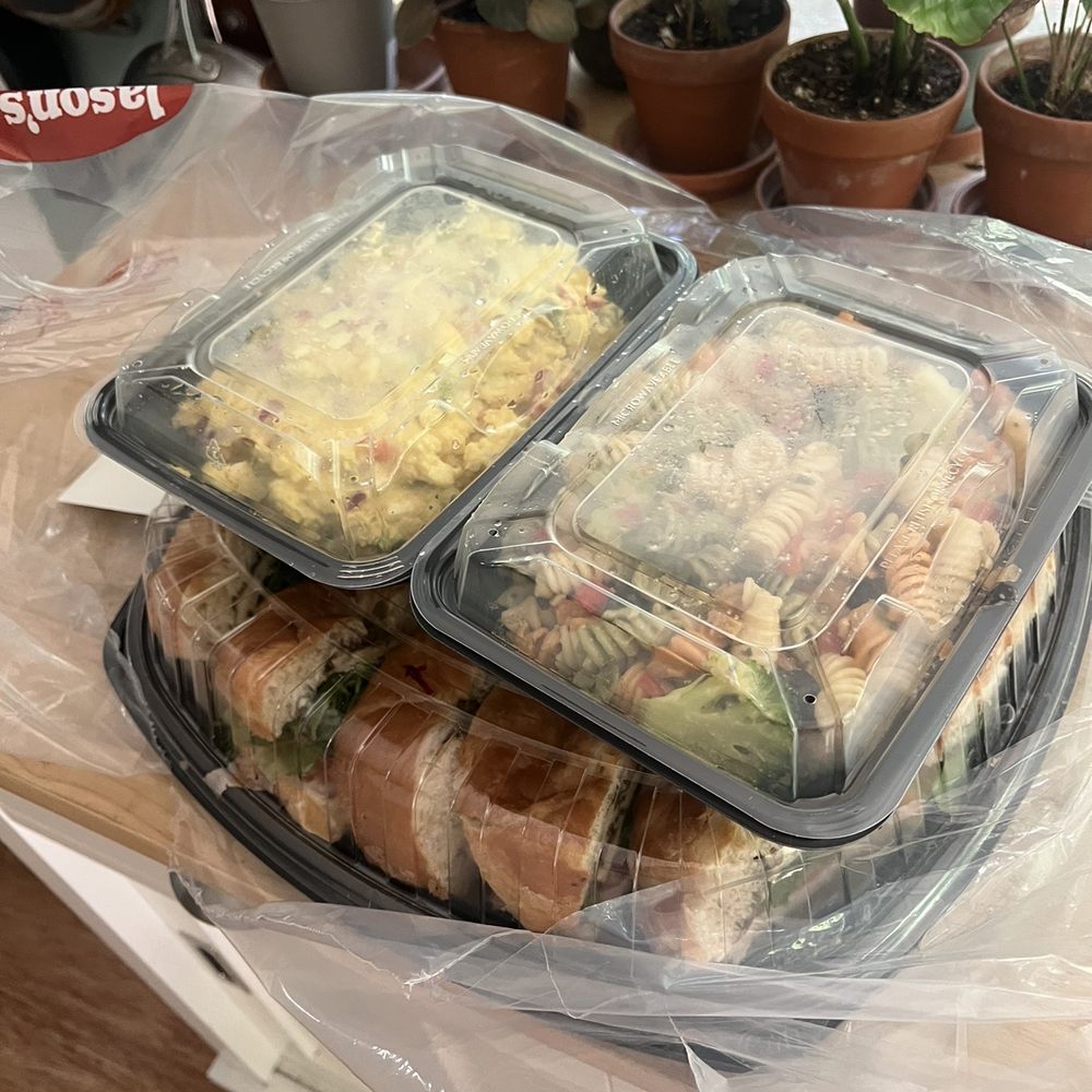 Huge tray of sandwiches with pasta salad and potato salad
