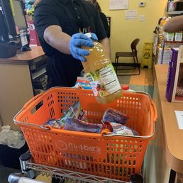 a grocery worker wearing a face mask and gloves a grocery worker wearing a face mask and gloves