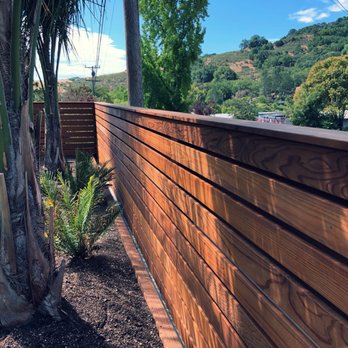 Greenport Construction - a wooden fence with a palm tree in the foreground - Carpenters Near Me - San Rafael, California Greenport Construction - a wooden fence with a palm tree in the foreground - Carpenters Near Me - San Rafael, California