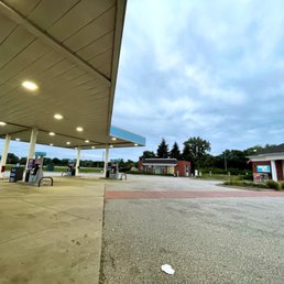 a gas station with a car parked in front of it a gas station with a car parked in front of it
