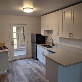 Go ADU Construction - a kitchen with white cabinets and black appliances - General Contractors Near Me - Burbank , California