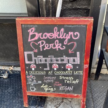 Brooklyn Perk - A chalkboard sign outside Brooklyn Perk features colorful handwritten text promoting a chocolate latte and its health benefits. - Coffee & Tea Near Me - Brooklyn, New York