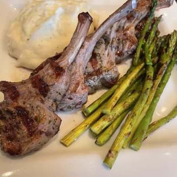 Frix's Fire Grill - Delicious Lamb chops , asparagus and fantastic mashed potatoes - Lamb chops are served with grilled asparagus and a side of mashed potatoes on a white plate. - Latin American Near Me - Chester, Maryland