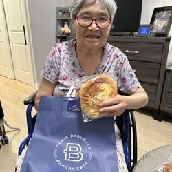 Belmont Village Senior Living - Los Gatos - July 2025: Alert, happy, eating Japanese an-pan by herself.