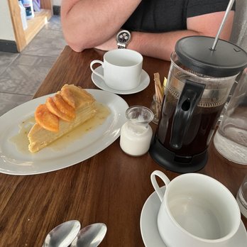The Little Hen - a man sitting at a table with coffee and pastries - French Near Me - Haddonfield, New Jersey The Little Hen - a man sitting at a table with coffee and pastries - French Near Me - Haddonfield, New Jersey