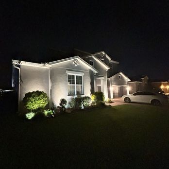 All Seasons Sprinkler and Landscape Lighting - Uplighting installed in the front of the house and a well light on the ground in front of the garage - Irrigation Near Me