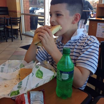 Subway - a boy sitting at a table eating a sandwich - Sandwiches Near Me - Zion Crossroads, Virginia