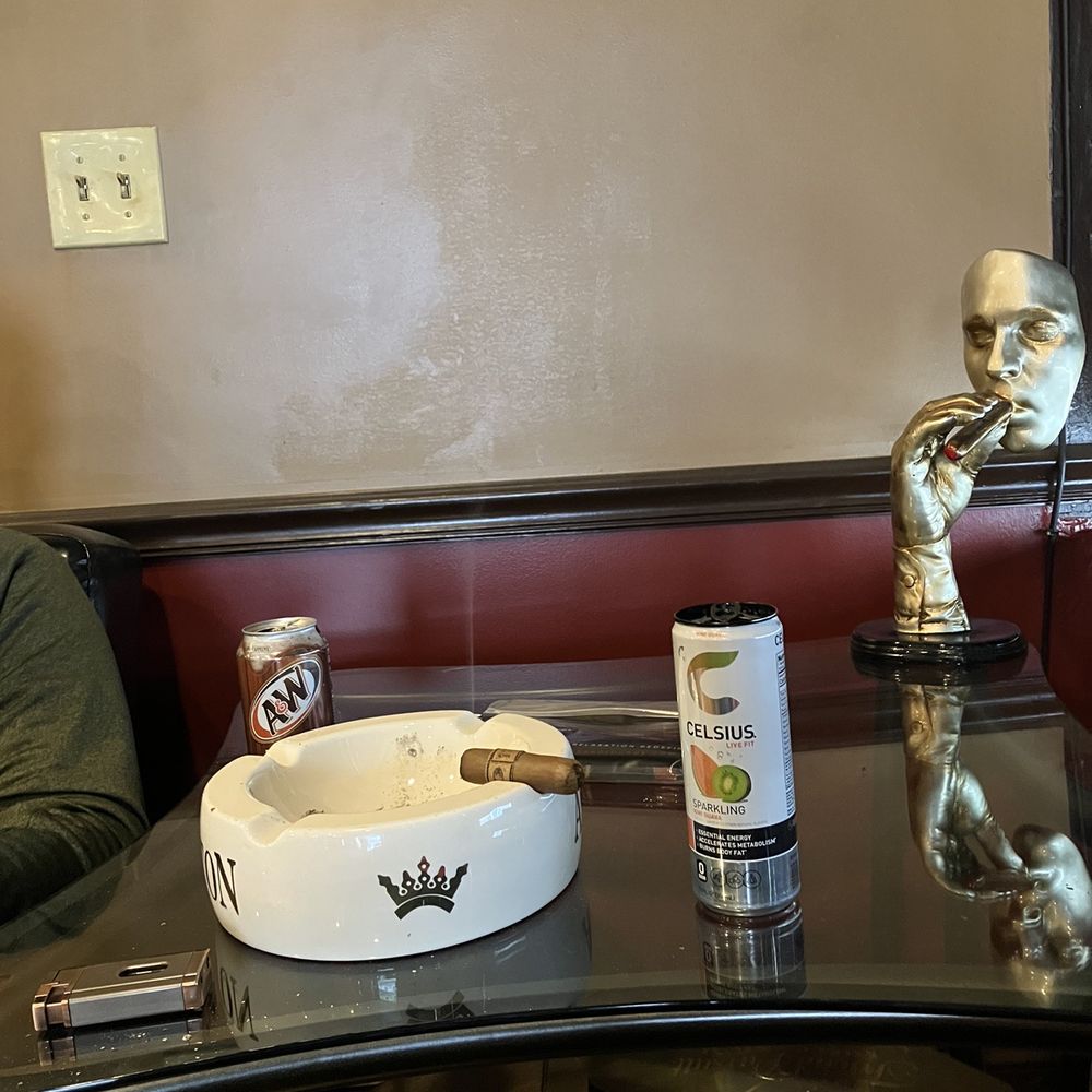 Cigar and Lounge - a man sitting at a table - Tobacco Shops Near Me - Watertown, Massachusetts