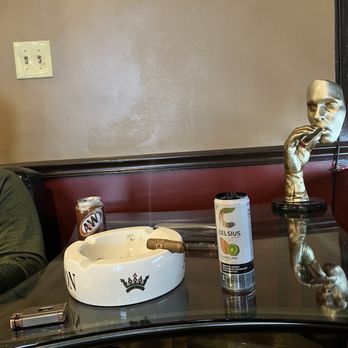 Cigar and Lounge - a man sitting at a table - Tobacco Shops Near Me - Watertown, Massachusetts