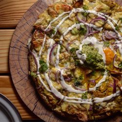 Illuminati Pizza - Chilaquiles pizza with guacamole and two sunny side eggs