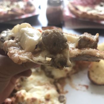 Luna Pizza - a hand holding a piece of pizza - Pizza Near Me - Fredericton, New Brunswick