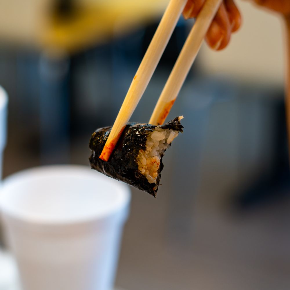 Kukga Topokki - a person holding chopsticks over a piece of sushi - Korean Near Me - Duluth, Georgia Kukga Topokki - a person holding chopsticks over a piece of sushi - Korean Near Me - Duluth, Georgia
