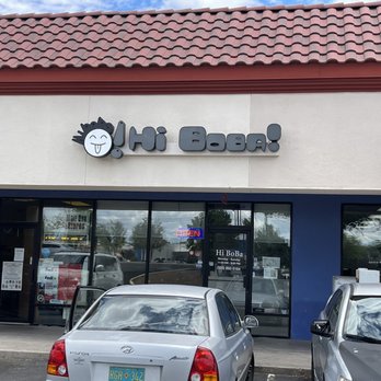 Hi Boba - Hi Boba bubble tea shop storefront with a sign displaying a cartoon face and playful text, large glass windows, and parked cars outside. - Coffee & Tea Near Me - Rio Rancho, New Mexico