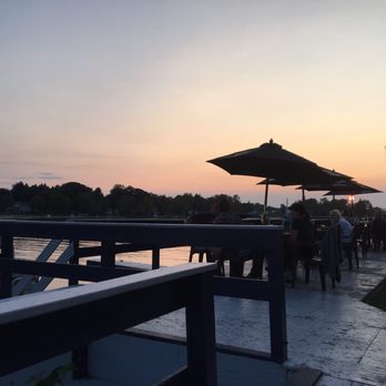 916 Riverside - a group of people sitting on a dock at sunset - American Near Me - Central Square, New York