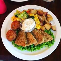 "Catfish" tofu with flavorful cornmeal breading, vegan tartar sauce, sautéed corn and broccoli, smothered potatoes, and hush puppies.