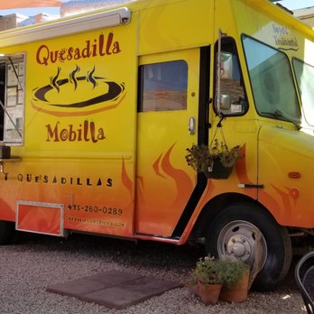 Quesadilla Mobilla - A yellow food truck with orange gradient accents displays the Quesadilla Mobilla logo and contact information, parked outdoors in Moab, Utah. - Fast Food Near Me - Moab, Utah