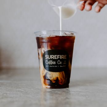 Surefire Coffee - a person pouring milk into a cup - Coffee & Tea Near Me - Nashville, Tennessee