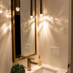 Wendt Electric - Modern bathroom vanity with custom pendant lighting, marble countertops, and luxury interior lighting design for elegant spaces.