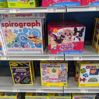 Michaels - Activities - The image shows store shelves stocked with craft kits and toys, including plush craft sets with animal designs, spirograph drawing kits, and origami paper folding sets. Price tags are visible, with some items priced at around $19.99 to $29.99. The packaging features colorful graphics and images of the craft activities, aimed at children and craft enthusiasts. The shelves are organized with multiple boxes of each product, and the background includes additional craft supplies and kits. - Arts & Crafts Near Me - Toronto, Ontario