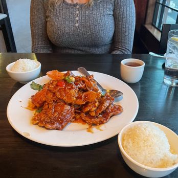 Rain Modern Chinese - a woman sitting at a table with a plate of food - Dim Sum Near Me - Albany, New York